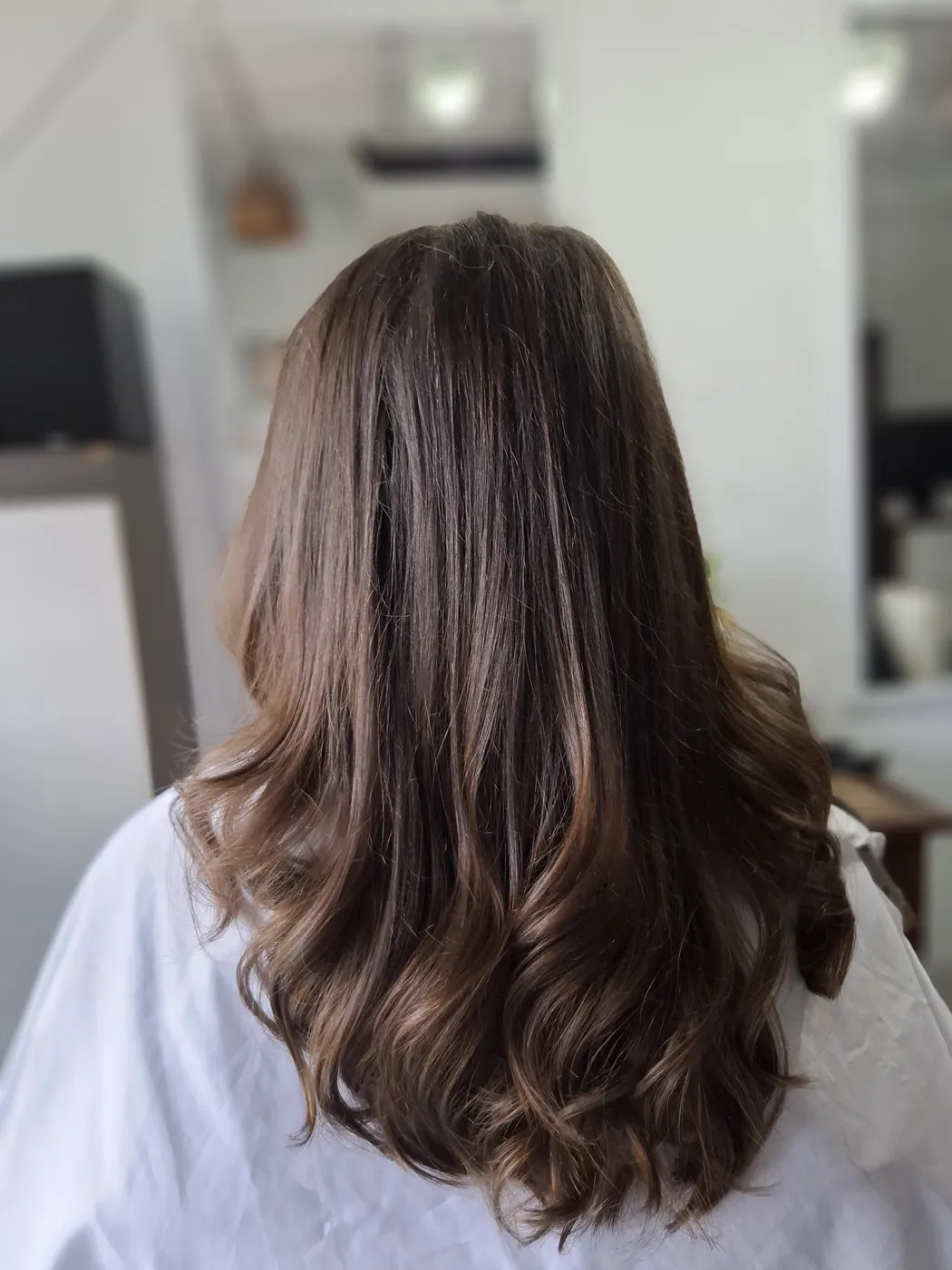 Brown hair blow dried into soft waves, seen from behind