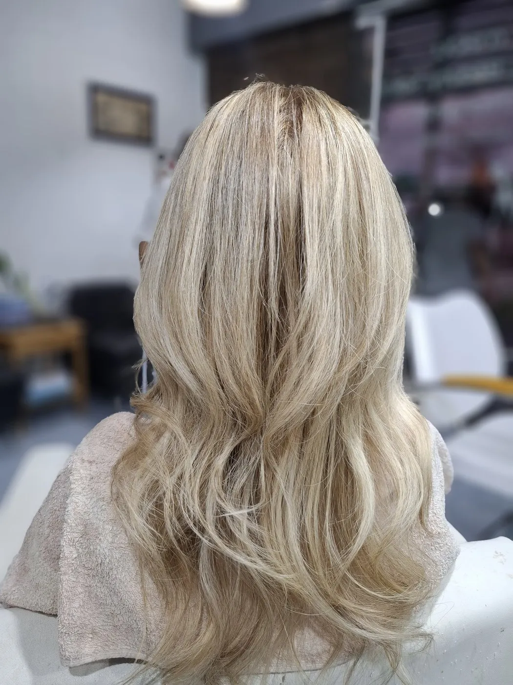 Long blonde hair in soft waves, from behind